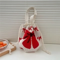 Detail der weißen gestrickten Beuteltasche mit roten Schleifenmustern und dicker Textur - Große Schleife Rot