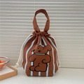 Detail of a brown knitted drawstring handbag with a cute cartoon bear and blue stripes - Brown Striped Dog