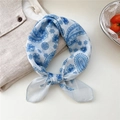 Blue and white paisley floral cotton linen scarf tied on beige fabric backdrop - Snowflake Paisley Blue