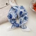 Floral paisley linen scarf in blue and white, tied in a knot on a beige fabric - Peacock Floral Grid White