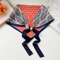 Detailed macro view of an elegant neck scarf with floral print and pearl magnetic buckle - Pearl Buckle - Five-petal Orange Flower