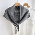 Vista detallada de la textura del pañuelo triangular de punto gris calado y etiqueta - Valla de Rayas Gris Medio