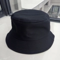 Top-down view of a classic black cotton bucket hat with durable fabric texture details - Black