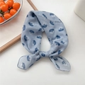 Light blue linen square scarf with floral print tied in a bow on a white tray - 17 Blue Heap Leaf