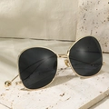 Lunettes de soleil oversize dorées avec verres foncés sur un socle en pierre naturelle - Monture Or Noir Gris