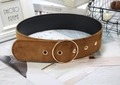Close-up of brown velvet waist belt featuring a large gold circular metal buckle and eyelets - Round Buckle Camel