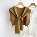 Detail of warm brown knitted shawl tied over a white shirt on a wooden hanger - Bronze (02D)