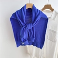 Detalle del chal de punto azul Klein con etiqueta tejida blanca en los puños - Azul