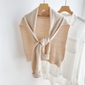 Detalle del chal de punto beige que muestra la textura fina y los bordes acanalados - Beige