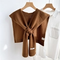 Close-up of caramel wool shawl showing the 100% WOOL label and fine knit texture - Brown