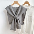 Detail shot of grey knitted wool shawl with 100% wool label on white shirt - Gray