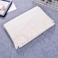 Soft white faux cashmere scarf with tassels, thick winter shawl for women folded on desk - Cream