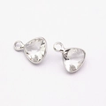 Detailed view of two triangle cut crystal birthstone pendants with silver claw settings - White