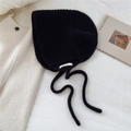 Détail du bonnet en laine noire montrant l'étiquette 100 % laine et le tissage épais - Bleu marine