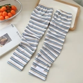 Detail of striped cooling arm sleeves with rib-knit texture and pink label on beige surface - One Size / Yellow and Blue Stripe