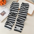 Detail of black and white striped sun protection arm sleeves with eggdoris woven label - One Size / Multistripe Black White