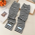 Close-up of black and white striped sun protection sleeves with a blue woven label logo - One Size / Two-tone Black White