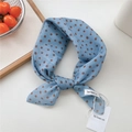 Light blue polka dot scarf with brown dots and brand tag on a clean white surface - Pebble Pattern Blue