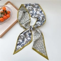 Green paisley print twilly scarf with silk texture laid on wood tray for accessories - Colorful Paisley Yellow Edge