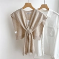 Dettaglio della maglia dello scialle in cashmere color avena con design a nodo frontale - caffè
