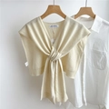 Dettaglio di uno scialle di lana a maglia beige crema con elegante nodo a torsione - crema