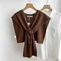 Detail of dark brown knitted shawl with cross-tie design layered over white shirt - Brown