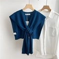 Detail of dark teal knit shawl with a front knot design layered over a white shirt - Navy Blue