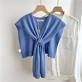Detail of sky blue knitted wool shawl with knot design styled over white shirt - Blue