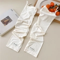 Close-up of white ribbed cooling arm sleeves with adjustable drawstring and knit texture - One Size / Beige