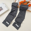 Detail of dark gray ribbed cooling sun sleeves with drawstring and white label on desk - One Size / Dark Gray