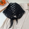 Vue détaillée du foulard triangulaire en dentelle noire sur une chemise beige - Flocon de neige / Noir