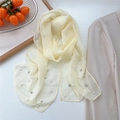 Écharpe en mousseline crème avec perles et strass sur un fond de style de vie chic - Jaune clair