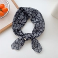 Square paisley bandana in black and white with a stylish knot on a white table - Black Paisley