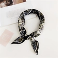 Detail of geometric pattern square silk scarf tied beside a lifestyle magazine on white - Clock Print