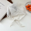 Elegante foulard bianco a pois annodato a fiocco su uno sfondo bianco minimalista - crema