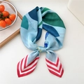 Foulard in seta azzurro con stampe geometriche e strisce rosse annodato a fiocco - 01 Singolo Fiore Blu