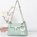 Chic mint green quilted crossbody bag with gold T-lock and cute plush monster charm - Green