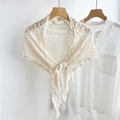 Detail showing hollow-out floral lace texture and tie-knot design on beige shawl wrap - Cream