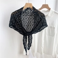 Close-up of black hollow floral crochet shawl lace pattern detail on a white shirt - Black