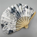 Detail showing grey and black floral fabric texture on a natural bamboo folding fan - No.1 Ink Gray