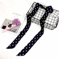 Close-up of elegant black and white polka dot silk scarf draped over a wire basket - Black Polka Dot