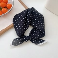 Foulard élégant en soie noire à pois blancs noué, posé sur une surface blanche épurée - 53x53cm / Petit pois Noir