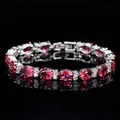 Vue macro d'un bracelet de luxe avec rubis ovales et zircons blancs sur fond noir élégant - Rouge