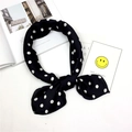 Sciarpa in seta a pois annodata a fiocco su una rivista con cartoline decorative - Pois Neri