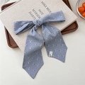 Blue floral silk scarf headband tied in a bow on a beige book and wooden tray - 11 Tie-Stippled Floral Leaves
