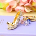 Golden high heel keychain with sparkling crystals and colorful beads on a book - Cinderella's Glass Slipper