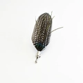 Detailed view of handmade feather brooch with black and white spots and green peacock sheen - Black With White Spots Guineafowl Style