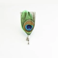 Detail van een natuurlijke pauwenveerbroche met zilveren speld op een witte achtergrond - Groen