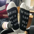 Funny mid-calf socks in black and white with 'Bring me a glass of wine' text on soles - One Size / Black & White
