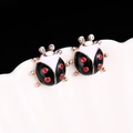 Macro shot of cute ladybug stud earrings with red enamel and sparkling crystal accents - E250-2 / Black